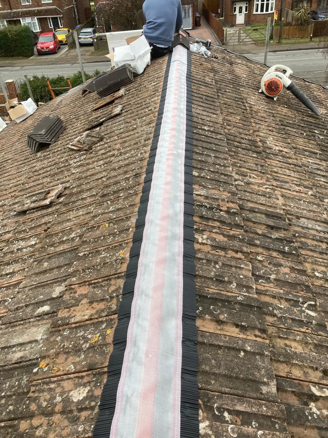 Dry ridge system being installed along a roof ridge